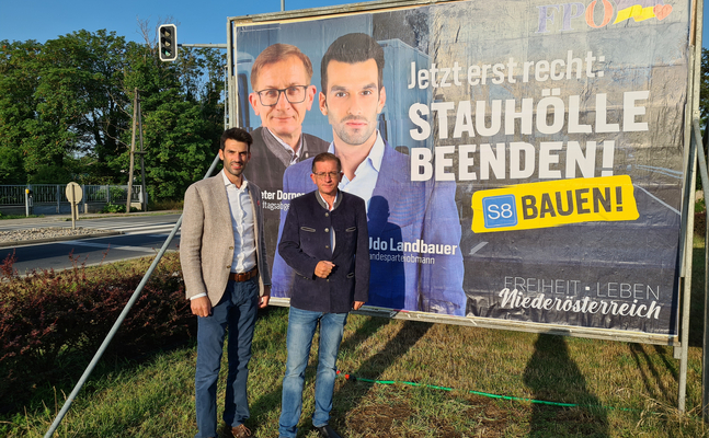 FPÖ-Landesparteiobmann Udo Landbauer und FPÖ-Verkehrssprecher Dieter Dorner präsentieren das Plakat zum Bau der S8. 